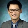 A headshot of Ji Yi in a suit and tie