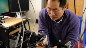 Jin Kang working with a handheld microinjector.