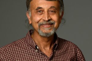 A headshot of Nitish Thakor wearing a brown checkered shirt.