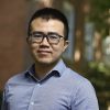 A headshot of Dingchang Lin wearing a blue shirt outdoors on the campus
