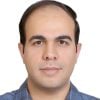 A headshot of Mahdi Mehrtash wearing a blue checkered shirt