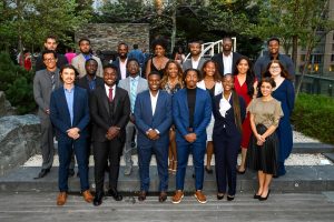 Students dressed up in formal attire, standing in 3 rows posing for a picture