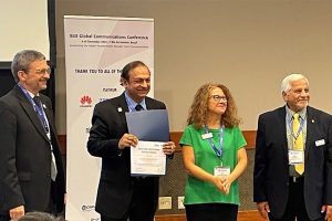 Ashutosh Dutta 2022 receives the IEEE-USA George F. McClure Citation of Honor, holding a citation while posing with IEEE officials.