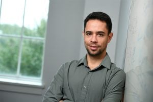 Jeremias Sulan poses for a headshot leaning against a white board.