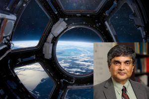 A headshot of Somnath Ghosh on a picture of the view of the earth from the Cupola porthole on the International space station.