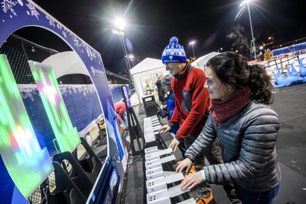 Students play with Persephone, a light and sound organ, at the ice rink in February 2023