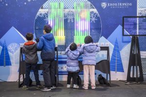 Chilren play with Persephone, a light and sound organ, at the ice rink in February 2023