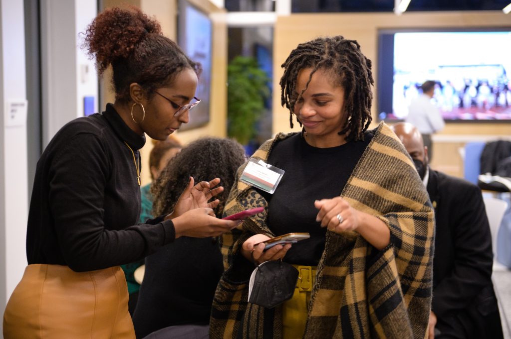 Two students looking at a phone during Black Excellence Conference