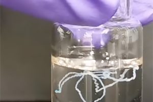 Hydrogel forms strands inside a solution in a test tube.