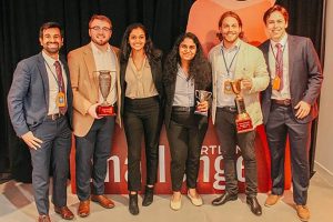 A group photo of six students on the Miraheart team holding trophies.