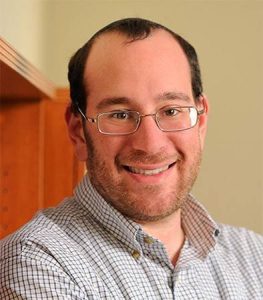 Mark Dredze, wearing a collared grey shirt. 