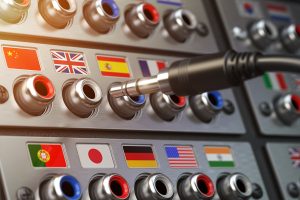 A switchboard with cable and various plugs labeled with national flags.