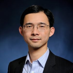 A headshot of Chao Wang a blazer.