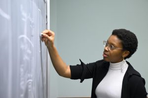 A student draws on a blackboard.