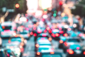 Blurred background of rush hour moment with defocused cars and generic vehicles.