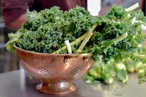 Kale seats in a table in a colander.