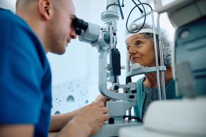 An ophthalmologist examines a patient with an ophthalmoscope.