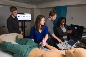 Bisi Bell and research team looking at mock human and an on-screen x-ray.