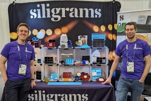 Clay Andrews and Ben Shay pose for a photo in front of their Silligrams product booth.