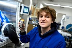 Liam McMullin holds a battery cell prototype developed to test composite cathodes with varied material ratios.