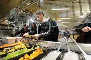 Image of students serving themselves food, cafeteria style.