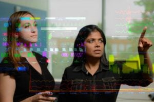 An image of Suchi Saria and teammate looking at a transparent screen