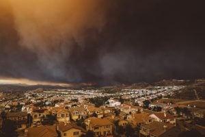 Smoke from Sand brush fire covering West Hollywood cityscape at sunset in California