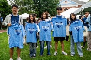 Group of students holding shirts from Meet The Flock