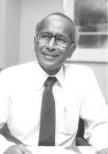 Black and white photo of Visvanathan “Raj” Rajagopalan in a shirt and tie. 