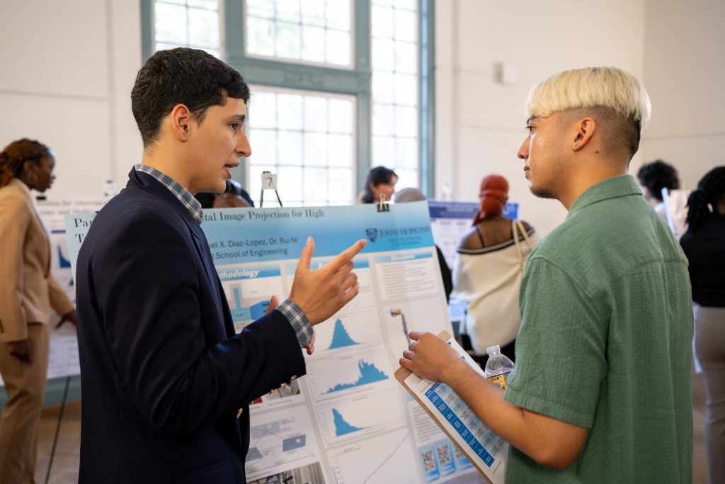 Graduate Ambassador Kyle Kaeo speaking with Propel participant during Propel Symposium